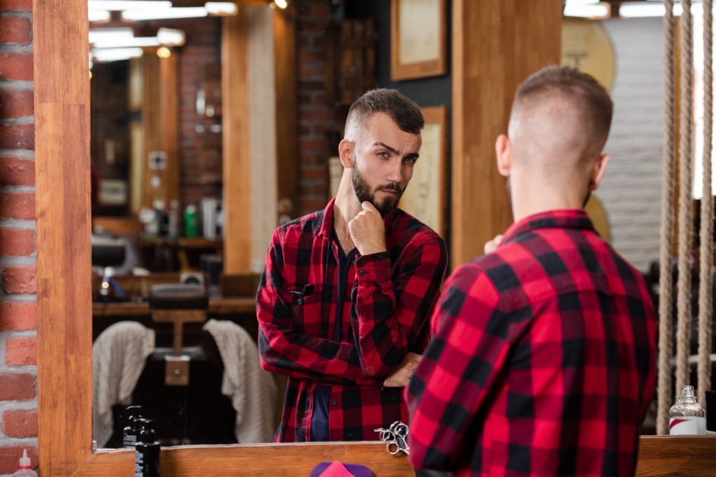 A gentleman looking at his reflection after his Fresh Haircut at the Fountains.
