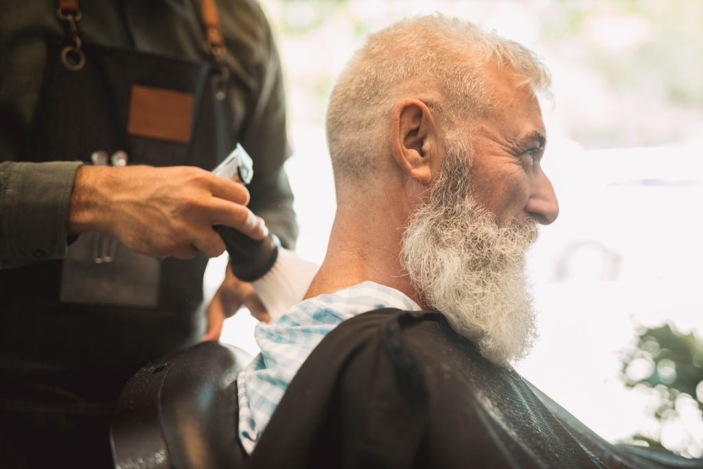 An elderly man having his Haricut at the Fountains Barber Shop