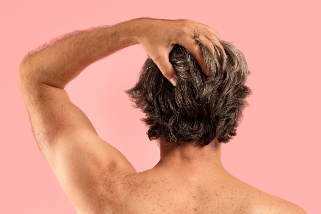 Back view of a gentlemand with a mens hair replacement system in Stafford.
