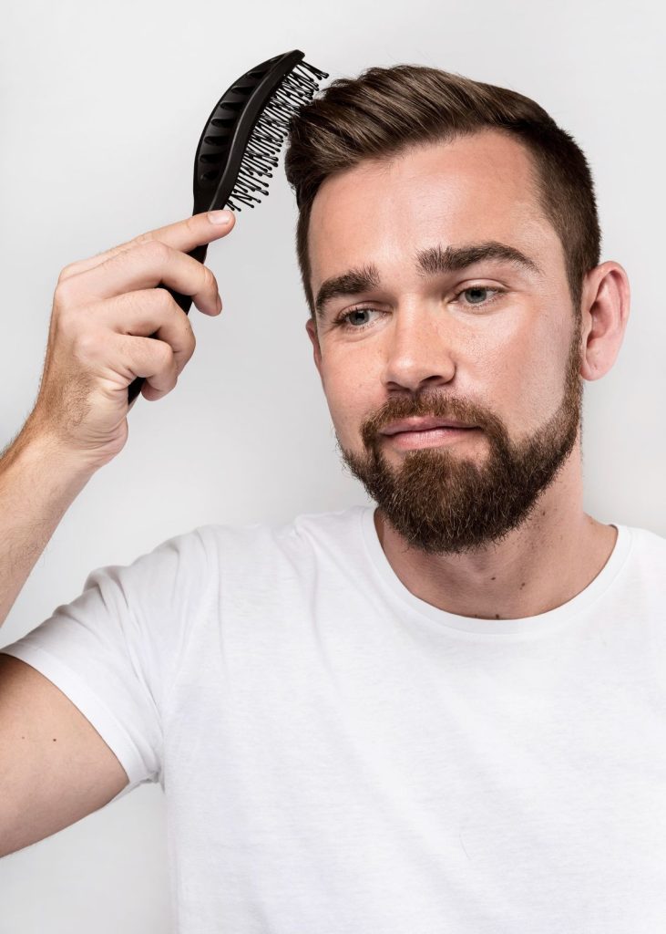Close-up of a man combing his fashionable hairstyle featuring a stylish mens toupee in Colony Lake Estates.