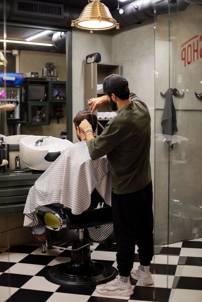Man getting a haircut at walk in barber shops near The Fountains