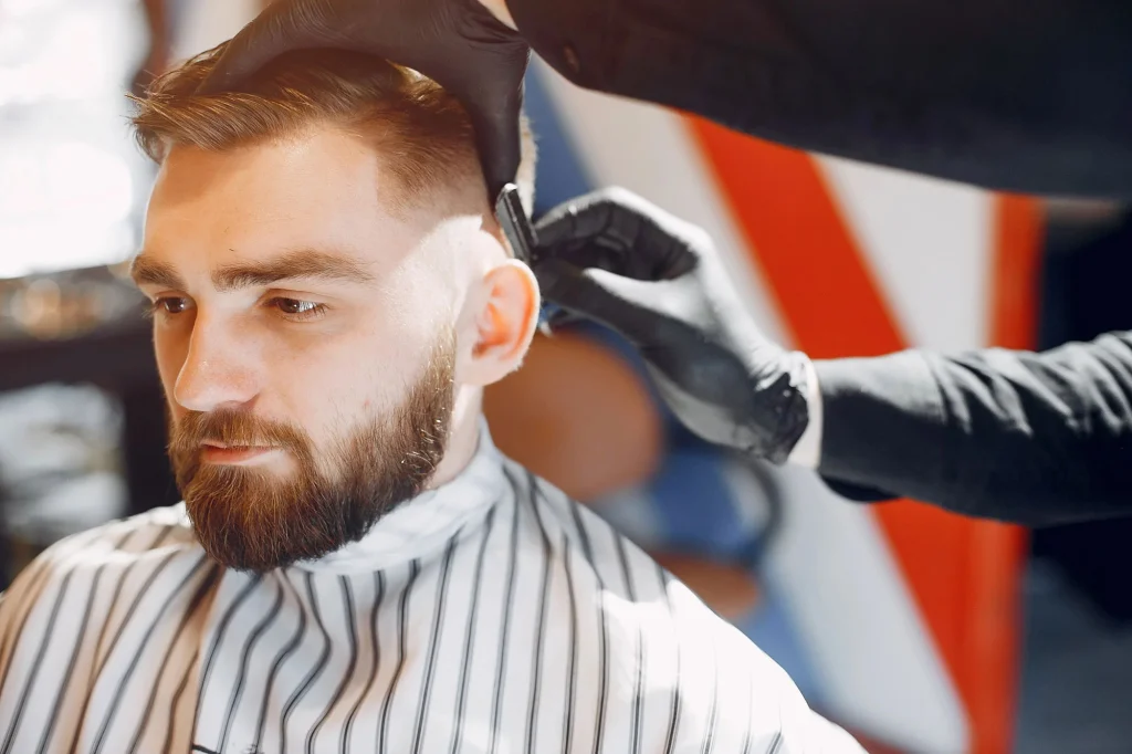 A barber giving a mens haircut with clippers in a stylish salon, focusing on a modern grooming experience.