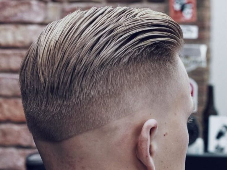 Modern fade haircut styled back in a classic barbershop, showcasing precision and style.