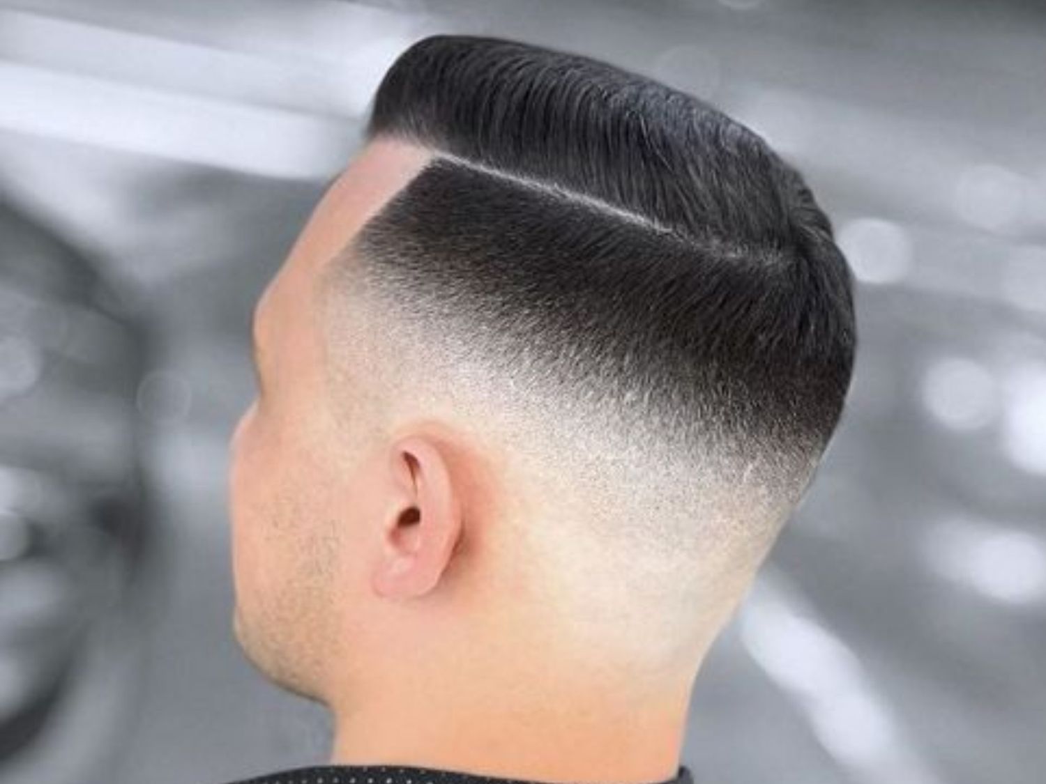 Barber trimming hair with precision in a stylish barbershop, highlighting expertise and modern grooming.