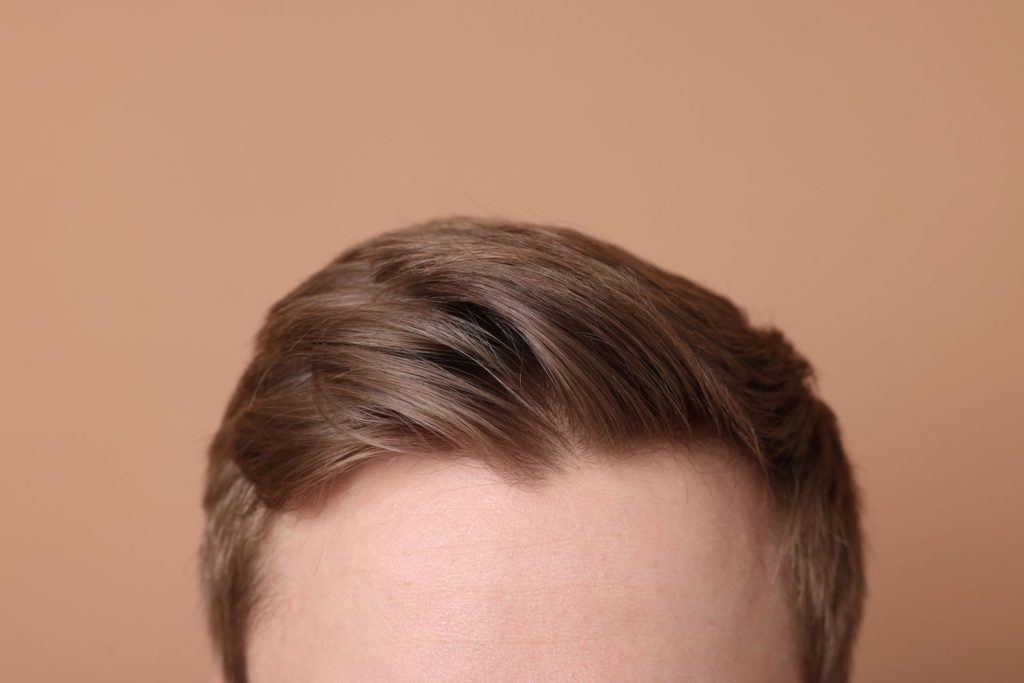 Close-up of a natural men's toupee in Stafford, featuring a well-groomed brown hairstyle on a man.