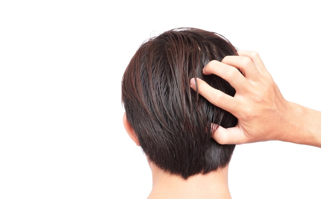 Hand adjusting a man's hairpiece, showcasing a Mens Toupee Stafford for natural hair restoration.