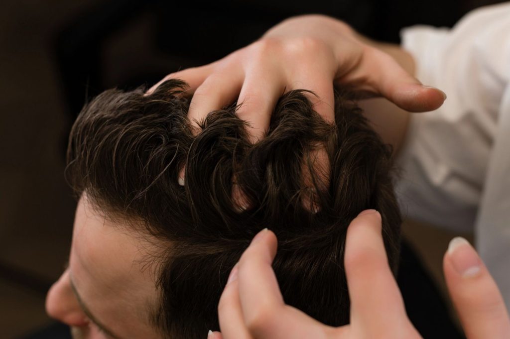 Stylist fitting a Mens Toupee Stafford on a client, offering seamless hair replacement solutions.