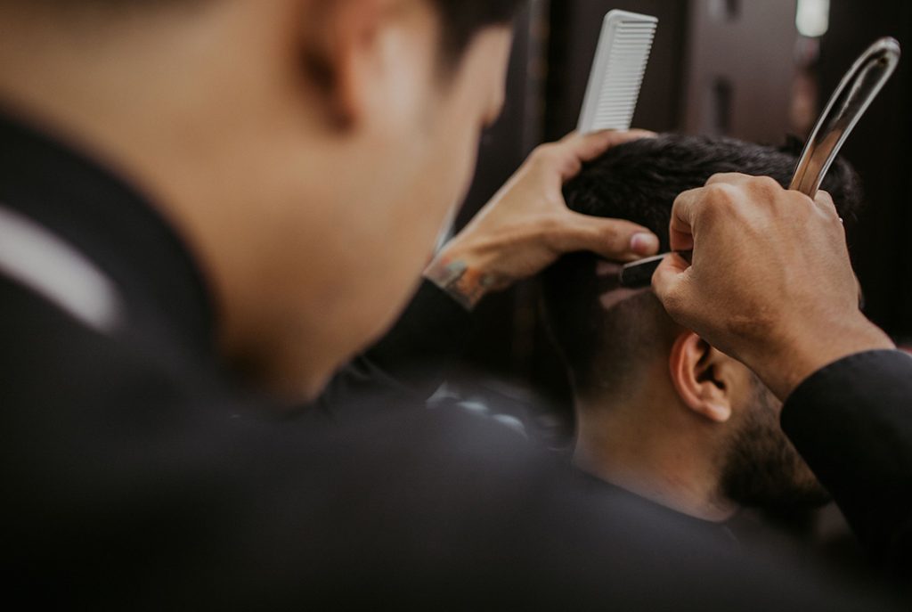 Straight razor clean-up on a haircut's edge for a crisp line, common at cheap barber shops.